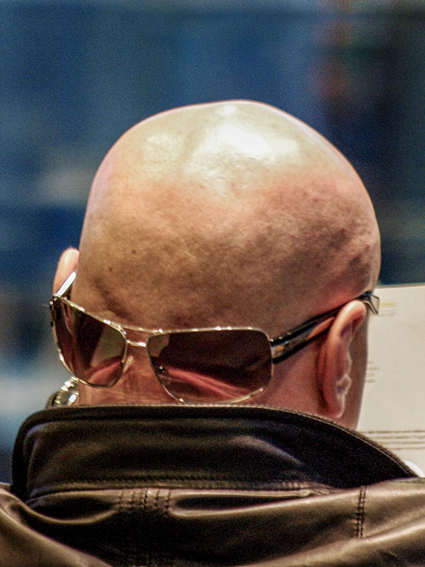 Bald man with looking away with sunglasses looking back
