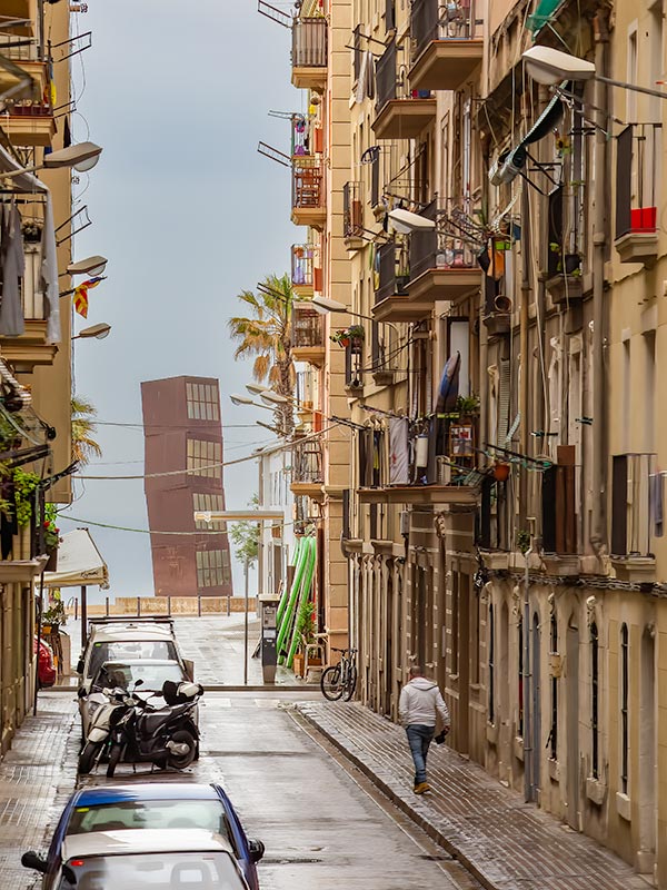 Man walking Barcelona side street after rain
