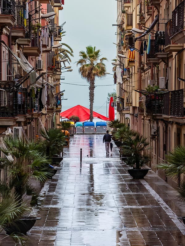 Man walking down street toward harbor after rain