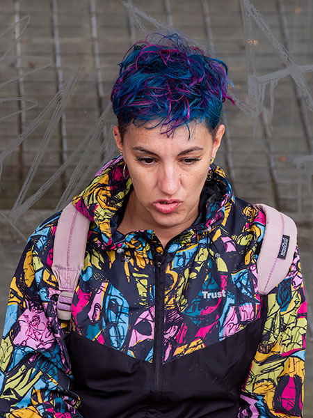 Woman with blue and pink hair matching her coat, Barcelona street scene