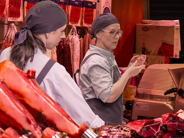 Two women meat vendors in Barcelona marketplace