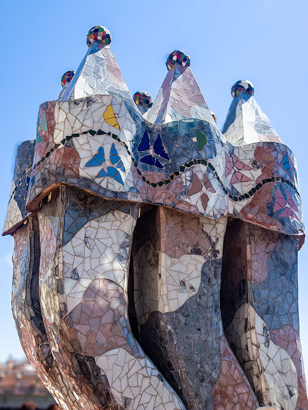 Unusual shaped columnar sculptures on roof of Gaudi designed house in Barcelona.