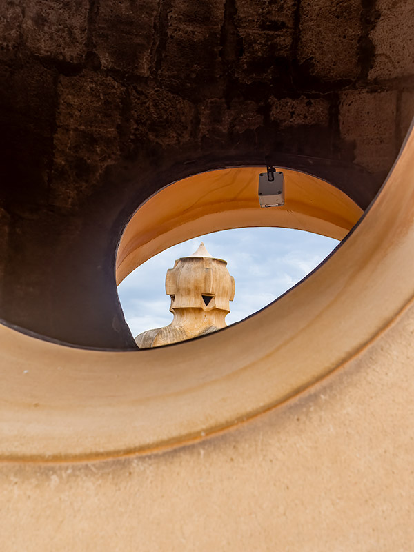 Unusual shaped sculpture seen through stairs on roof of Gaudi designed house in Barcelona.