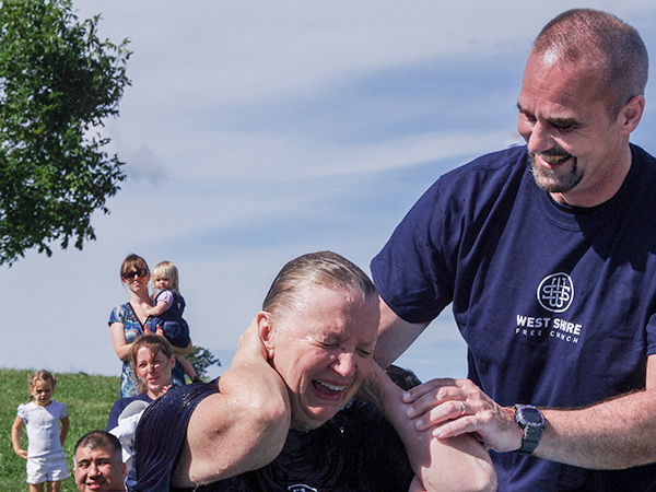 Woman rejoicing beside smiling man who baptised her