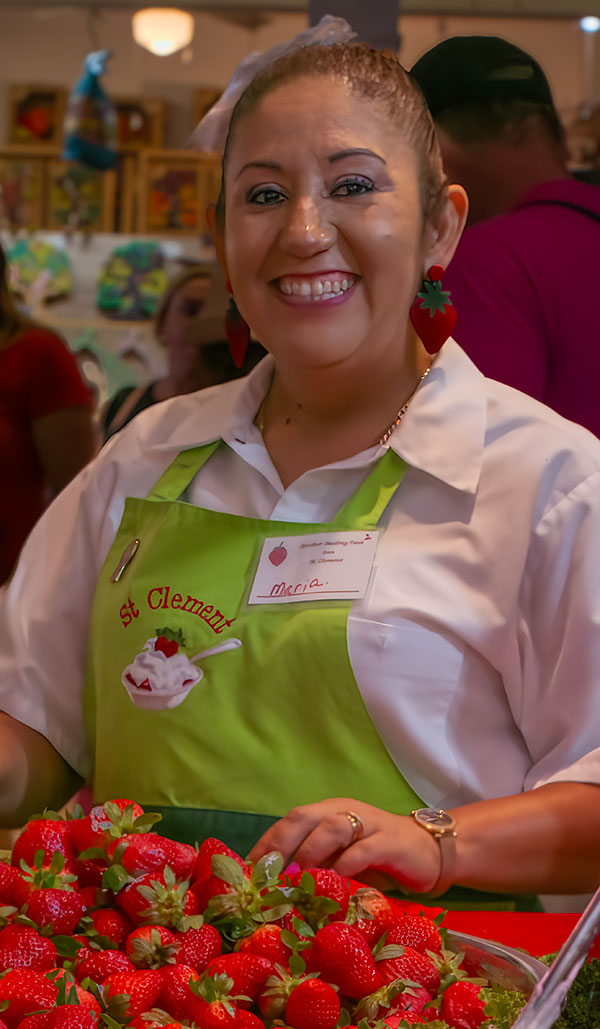 Smiling woman working a strawberry concession at a festival