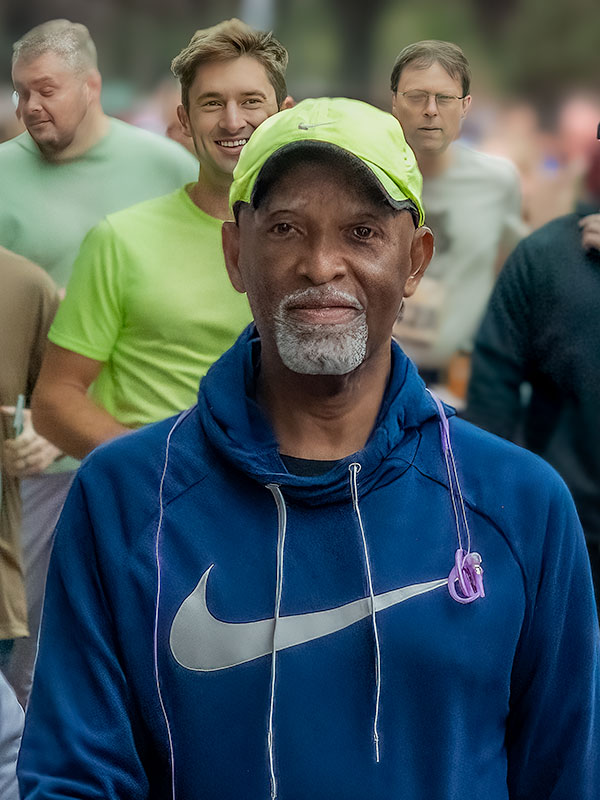 Content, older runner posing after race