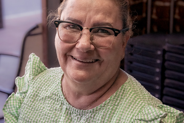 Smiling woman looking up from cigar-making work